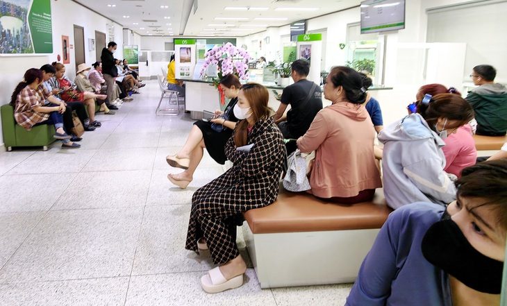 Khách hàng chờ đến lượt giao dịch tại ngân hàng trên đường Phan Đăng Lưu, quận Phú Nhuận trong sáng 2-7 - Ảnh: ĐỨC THIỆN